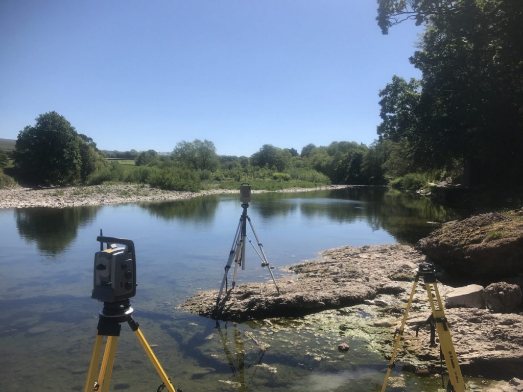River bank survey with a 3D scanner and a total station on a sunny day