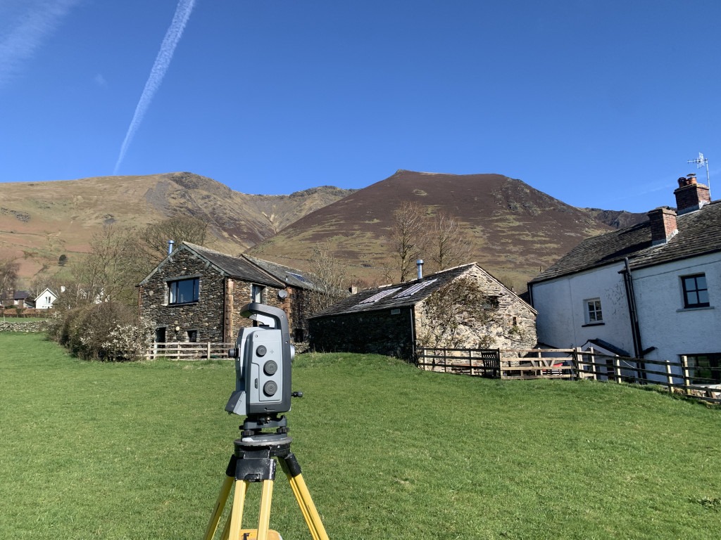 Land surveying in a field with Blencathra in the background